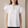 White FJØRNA summer blouse for women with cap sleeves and ruffle detail, perfect for warm weather and casual outings.