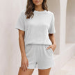 White ribbed knit two-piece set with relaxed drop shoulder top and mini shorts by FJØRNA, perfect for casual wear.