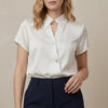 White FJØRNA summer blouse for women with short sleeves and stylish cut-out details, perfect for warm weather.
