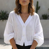 White women's summer blouse with V-neck and high waist, stylish top from FJØRNA for warm weather wear.