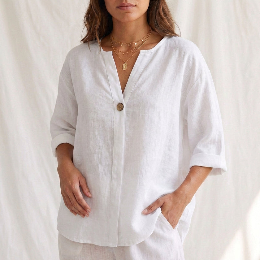 White women's summer blouse by FJØRNA featuring a V-neck, linen fabric, and button-front design.