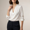 White women's satin summer blouse with V-neck, long sleeves, and high waist from FJØRNA, styled as a chic top.