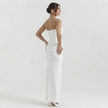 Side profile of a white women's strapless corset maxi dress by FJØRNA, featuring a fitted bodice and flowing skirt.