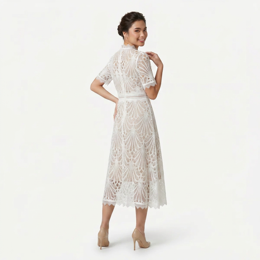 White women's lace midi dress by FJØRNA, high neck design with refined cutwork, shown from the back in a profile pose.