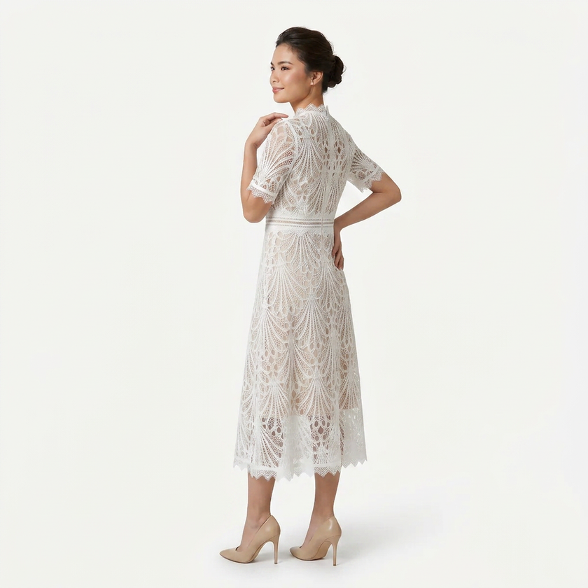 White women's FJØRNA lace midi dress with high neckline and elegant cutwork, shown in a side profile pose.