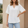 White women's summer blouse with V-neck and flutter sleeves by FJØRNA, shown on a hanger.