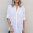 White women's summer blouse with V-neck and denim button front by FJØRNA, shown on a model.