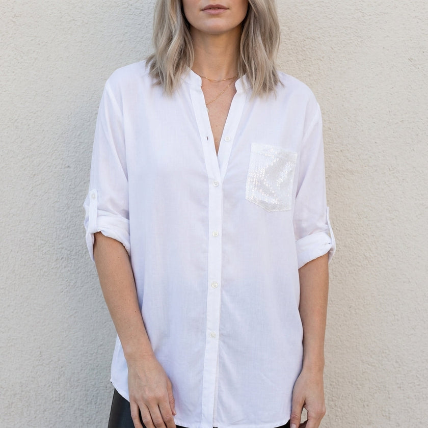 White women's summer blouse with V-neck and denim button front by FJØRNA, shown on a model.