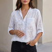 White floral V-neck denim summer blouse for women by FJØRNA, featuring a stylish and breathable top with a relaxed fit.