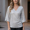 White FJØRNA women's summer blouse with V-neck and sequin embellishments, stylish top for warm weather.