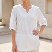 White floral V-neck linen summer blouse for women by FJØRNA, flowy and lightweight top perfect for warm weather.