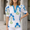 White floral summer blouse for women by FJØRNA featuring a V-neck, puff sleeves, and high waist, perfect for warm weather.