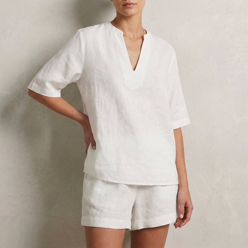 White FJØRNA summer two-piece women's co-ord set with V-neck top and matching pants featuring pockets, casual and stylish.