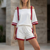 White FJØRNA sporty contrast trim two-piece set with relaxed off-shoulder top and matching pants, casual and stylish ensemble.