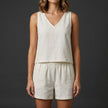 White FJØRNA women's summer two-piece pleated V-neck co-ord set featuring a stylish top and matching skirt.