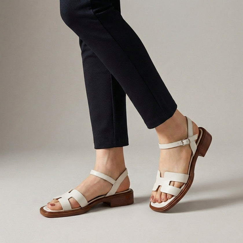 White FJØRNA ankle-length flat sandals with ankle strap and buckle, showcasing their minimalist design and comfortable fit.