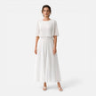 Women's white chiffon pleated maxi dress by FJØRNA, flowing design with pleats, suitable for wedding guests.