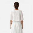 Women's white chiffon pleated maxi dress by FJØRNA, featuring elegant flowy fabric and a flattering fit, perfect for wedding guests.