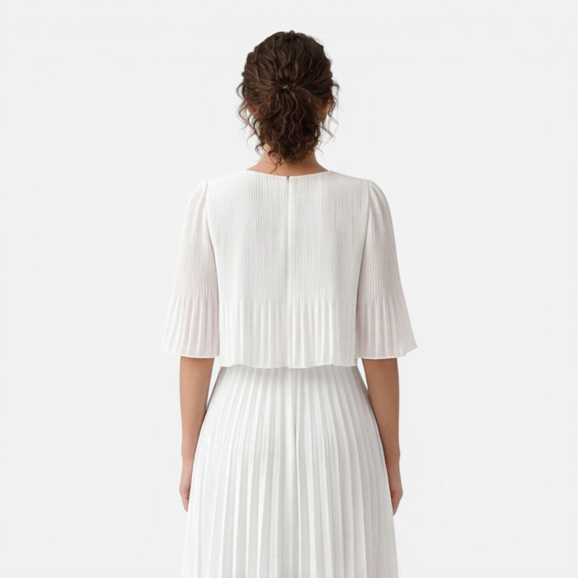 Women's white chiffon pleated maxi dress by FJØRNA, featuring elegant flowy fabric and a flattering fit, perfect for wedding guests.