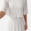 Women's white chiffon pleated maxi dress by FJØRNA, flowing style with pleats, perfect for wedding guests.