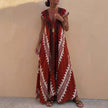 Wine red bohemian-inspired FJØRNA maxi dress with flowing A-line cut, deep V-neck, and geometric motifs, displayed on a hanger.