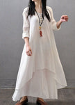 Women wearing FJØRNA white vintage maxi dress with long sleeves, double layers, button details, and asymmetric design.