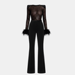 Women wearing a black lace sequin jumpsuit by FJØRNA, showcasing the stylish design and fitted pants detail.