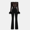 Women wearing a black lace sequin jumpsuit by FJØRNA, showcasing the stylish design and fitted pants detail.