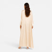 Woman wearing a FJØRNA women's draped sleeve maxi dress, flowing fabric, elegant design, full-length dress with draped sleeves.