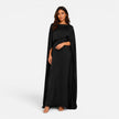 Woman wearing FJØRNA women's draped sleeve maxi dress with flowing fabric and elegant design, suitable for formal occasions.