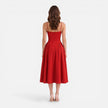 Women’s elegant midi dress by FJØRNA, strap A-line style perfect for wedding guests, displayed on a hanger against a neutral background.