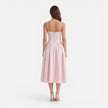 Elegant women's midi dress by FJØRNA with strap details, A-line silhouette, perfect for wedding guests, shown on a model.