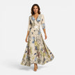 Women wearing FJØRNA floral wrap maxi dress with V-neck, showcasing elegant silhouette and vibrant floral pattern.