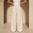 Women’s high-waisted tailored wide-leg trousers by FJØRNA displayed on a model, showcasing the chic, structured fit and fabric details.