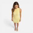 Women’s slim-fit knit mini dress by FJØRNA featuring sleeveless design and mock neck, shown in a close-up of the dress on a model.