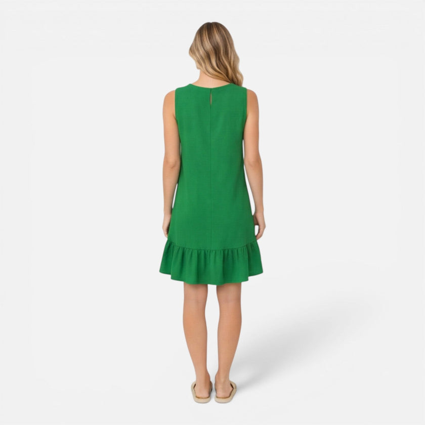 Women's lightweight summer sleeveless A-line dress with ruffle hem by FJØRNA, shown on a model in a bright outdoor setting.