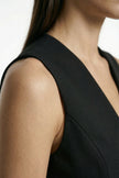 Black women's slim fit sleeveless waistcoat by FJØRNA, close-up showing tailored tailoring and layered design.