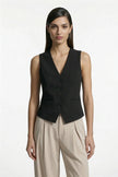 Black women's slim fit sleeveless waistcoat by FJØRNA, tailored for a sleek, layered look with a medium shot view.
