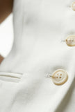 White women's slim fit tailored waistcoat by FJØRNA, sleeveless design, close-up shot highlighting fabric and tailoring details.