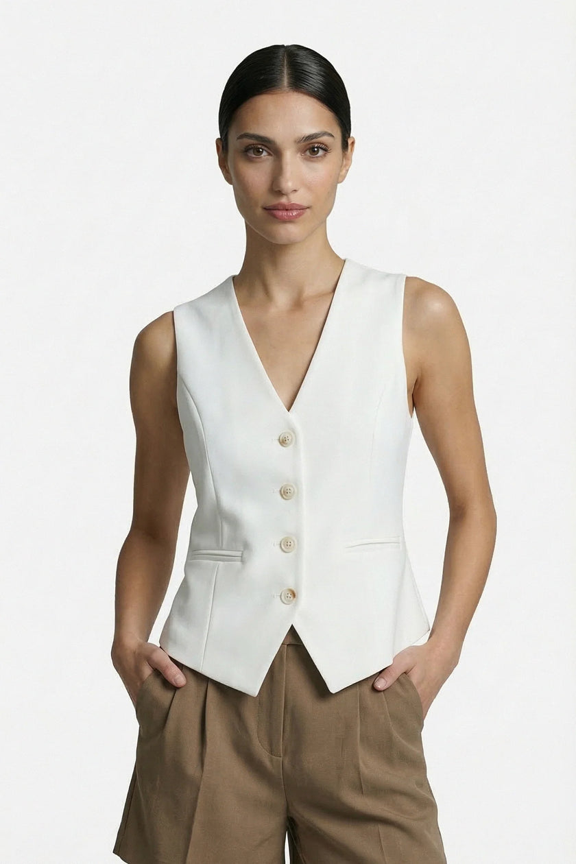 Women’s slim fit, sleeveless white waistcoat by FJØRNA, tailored for a sleek, layered look. Medium shot showing front details.