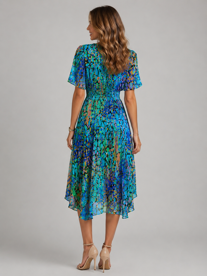 Women's floral V-neck midi dress with flutter sleeves by FJØRNA, shown with a flowing silhouette and vibrant floral pattern.