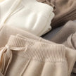 White woolen women's joggers by FJØRNA, cozy knitted wide-leg pants perfect for fall and winter outdoor wear.