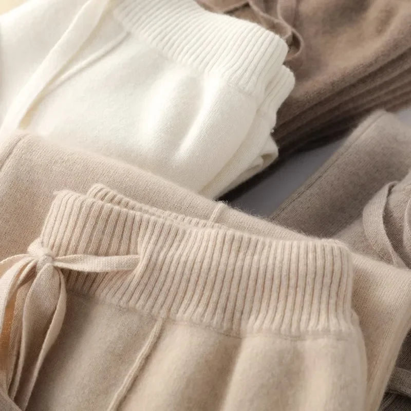 White woolen women's joggers by FJØRNA, cozy knitted wide-leg pants perfect for fall and winter outdoor wear.