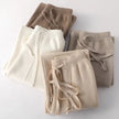 White woolen women's joggers by FJØRNA featuring knitted, wide-leg design for fall and winter outdoor wear.