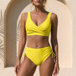 Yellow FJØRNA fitted wrap front bikini with wide straps, showcasing the stylish swimwear design on a model.
