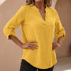 Yellow women's relaxed V-neck blouse with band collar and patch pocket, by FJØRNA, shown on a model.