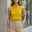 FJØRNA women's sleeveless yellow denim summer blouse with a relaxed fit, perfect for warm weather and casual outfits.