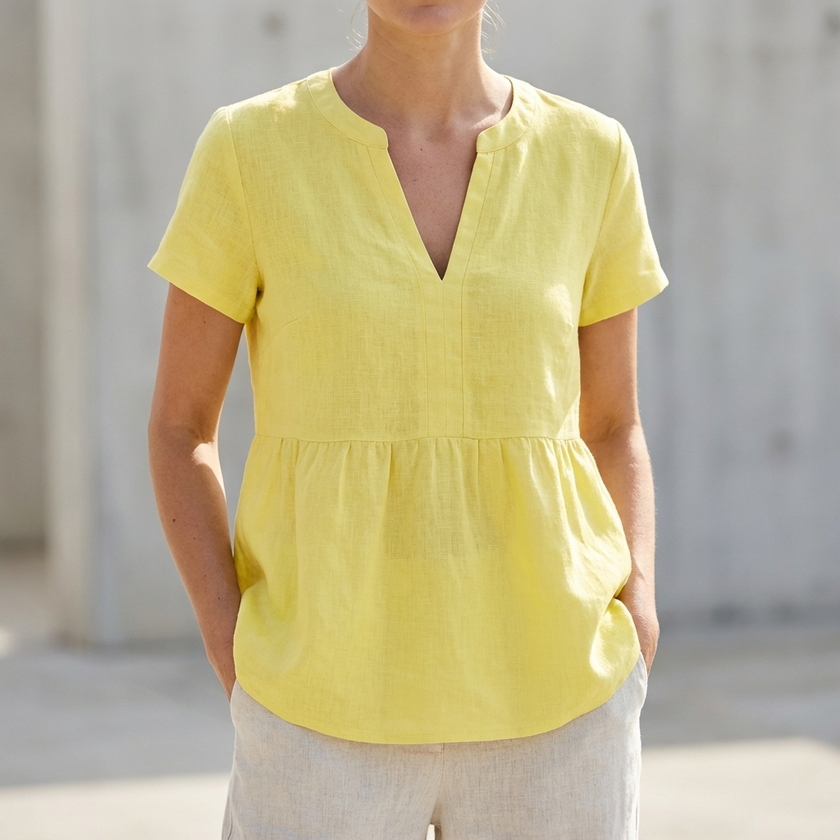 Yellow women's V-neck peplum blouse with pintuck detailing and curved hem, stylish top by FJØRNA.