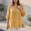 Yellow linen summer blouse for women by FJØRNA featuring stylish cut-out details and a relaxed fit.