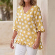 Yellow FJØRNA women's mini dress with V-neck and ruffle details, stylish and elegant for casual or special occasions.